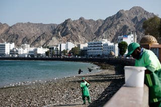 Workers clean the Muttrah Corniche waterfront promenade, amid the US-Israeli conflict with Iran, in Muscat, Oman, 3 March 2026